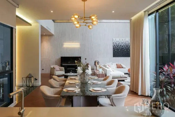 Detached House for rent or sale in Bang Kapi, Bangkok - Elegant dining area with marble table and gold chandelier, lounge and upright piano beyond.