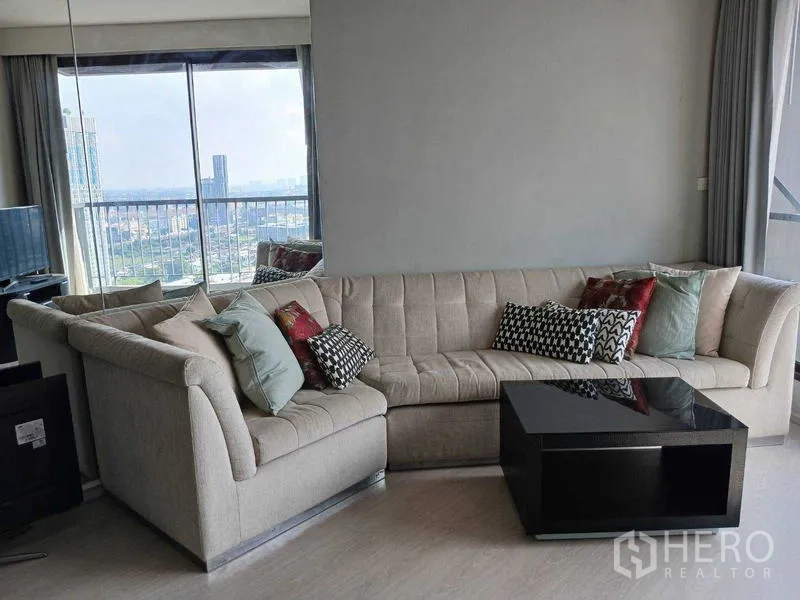 Condominium for rent - L-shaped sectional sofa with glossy coffee table by large window with panoramic city view.