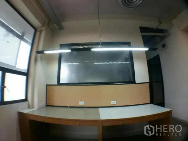 สำนักงาน ให้เช่าในPhra Khanong, Bangkok - โต๊ะทำงานพร้อมไฟแขวน แผ่นคอร์กบอร์ด และปลั๊กไฟหลายจุด
