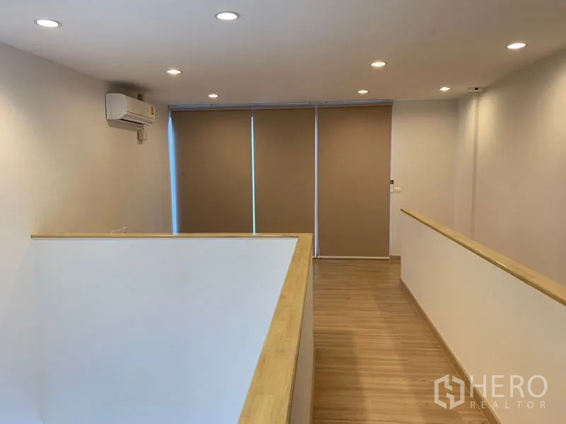 联排别墅 出租在Bang Na, Bangkok - 楼上走廊，木地板、空调与遮光窗帘