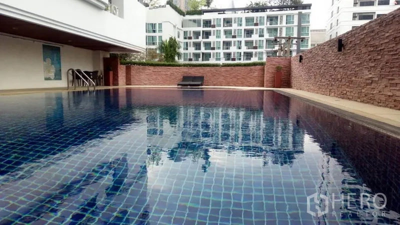 公寓 出租在Watthana, Bangkok - 室外泳池，蓝色马赛克池面与躺椅