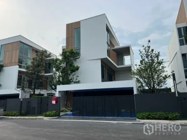 Detached House for rent or sale in Saphan Sung, Bangkok - Contemporary three-storey detached house with wood accents, tall windows and gated driveway in a Saphan Sung estate.