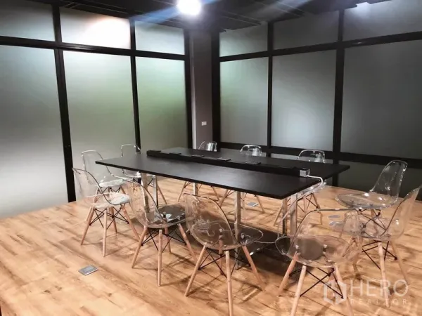 Office Space for rent in Bang Na, Bangkok - Boardroom featuring long conference table, clear acrylic chairs and frosted glass partitions.