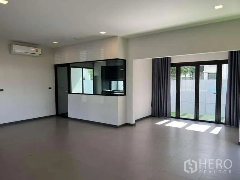 独立式住宅 出租或出售在Bang Phli, Samut Prakan - 开放式起居区，厨房传菜窗与可折叠门通向庭院。