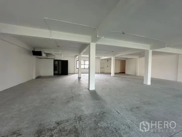 Office Space for rent in Khlong Toei, Bangkok - Bright empty office floorplate with windows on two sides and a marked emergency exit door.
