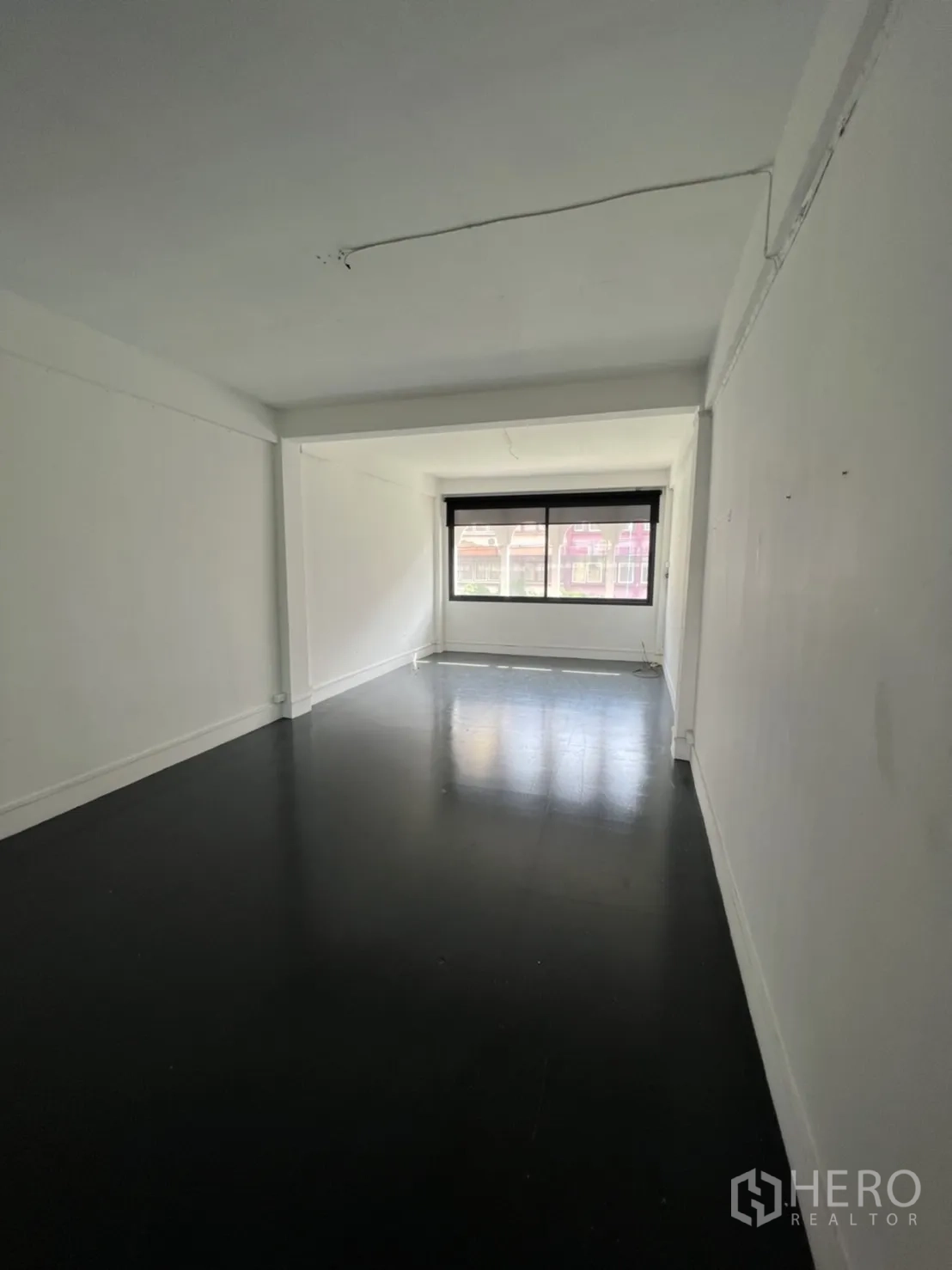 Shophouse for rent or sale in Watthana, Bangkok - Long open-plan room with window ideal for a studio or showroom.