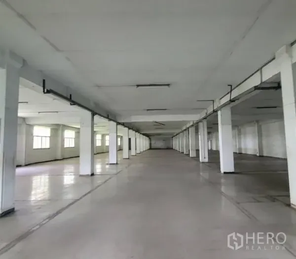 Factory for rent in Mueang Samut Prakan, Samut Prakan - Long industrial hall with rows of pillars and ceiling strip lighting