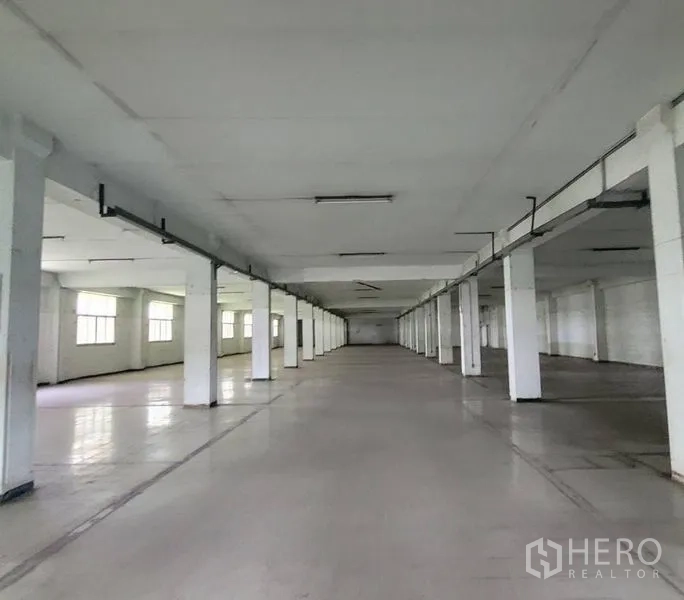Factory for rent in Mueang Samut Prakan, Samut Prakan - Long industrial hall with rows of pillars and ceiling strip lighting