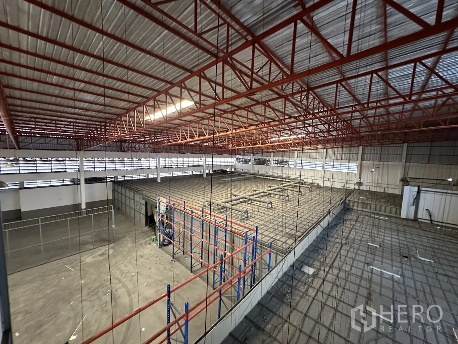 工厂 出租 - 钢结构屋顶下的货架区与封闭夹层全景。