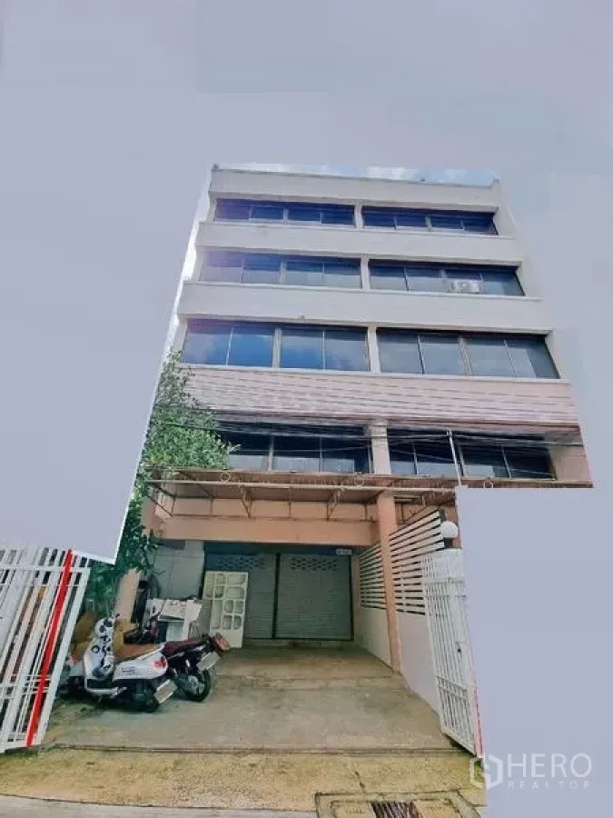 Office Space for rent in Din Daeng, Bangkok - Multi-storey commercial building exterior with gated driveway and a ground-floor shutter.