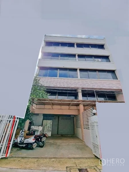Office Space for rent in Din Daeng, Bangkok - Multi-storey commercial building exterior with gated driveway and a ground-floor shutter.