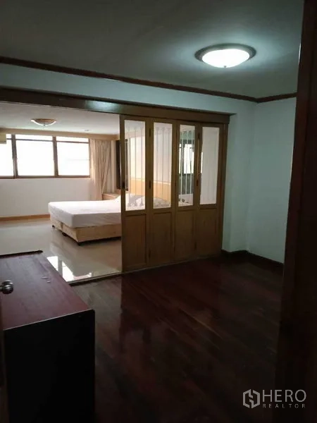 联排别墅 出租在Khlong Toei, Bangkok - 主卧套房，木玻璃推拉隔断与木地板