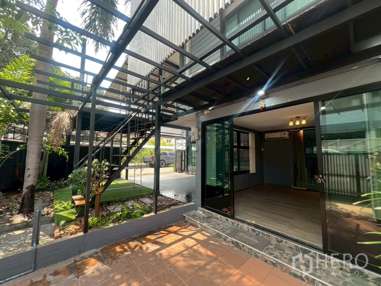 Detached House for rent or sale in Wang Thonglang, Bangkok - Ground‑floor terrace with exterior metal stairs and wide sliding doors.