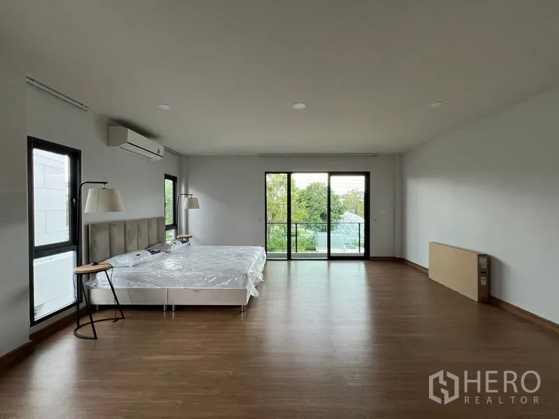 Detached House for rent or sale in Bang Phli, Samut Prakan - Large master bedroom opening to a balcony through sliding glass doors.