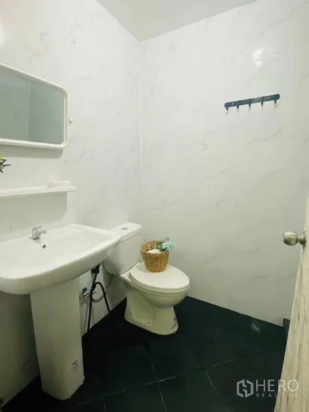 Condominium for rent or sale in Watthana, Bangkok - Guest washroom with pedestal sink, toilet and white tiled walls.