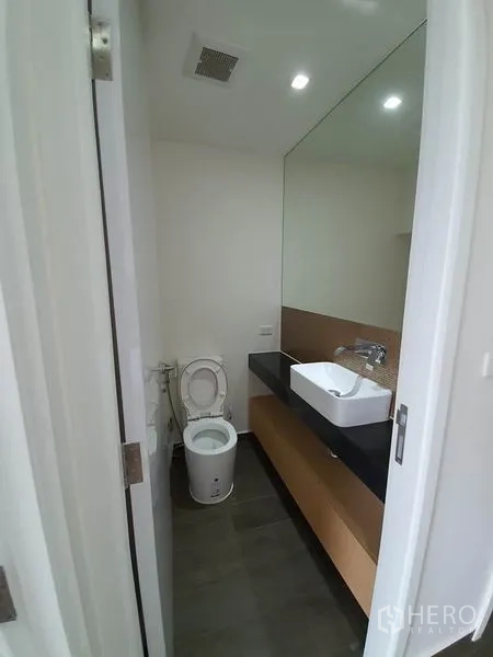 公寓 出租或出售在Watthana, Bangkok - 客用卫生间，台上盆与大镜面