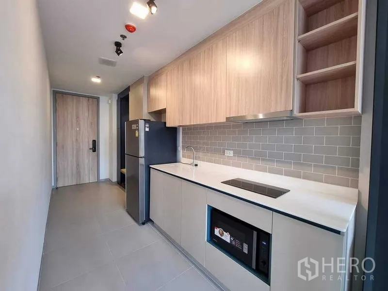 Condominium for rent in Ratchathewi, Bangkok - Contemporary kitchenette with light wood cabinetry and subway tile backsplash.