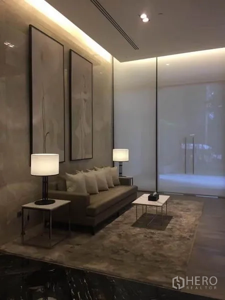 公寓 出租在Watthana, Bangkok - 典雅大堂休息区，沙发、台灯与大理石装饰。