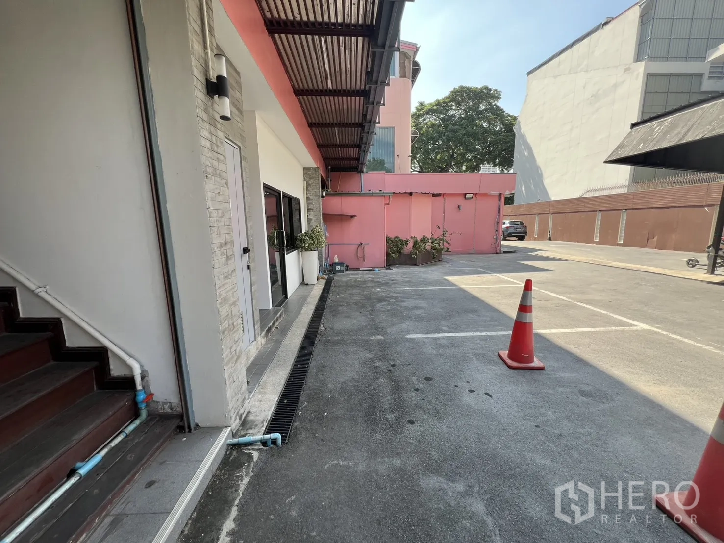 零售空间 出租 - 建筑旁的室外停车区与路锥。