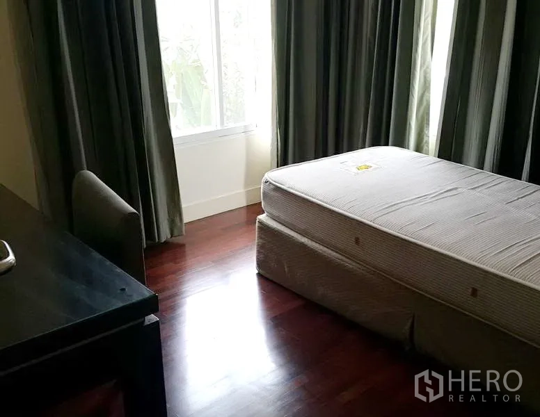 บ้าน ให้เช่าในWang Thonglang, Bangkok - ห้องนอนรอง พื้นไม้ เตียงเดี่ยว โต๊ะทำงาน และหน้าต่างบานใหญ่พร้อมผ้าม่าน