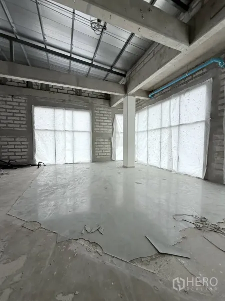 Retail Space for rent in Khlong Toei, Bangkok - Unfinished retail interior with high ceiling, concrete floor, brick walls and large covered windows ready for custom fit-out.