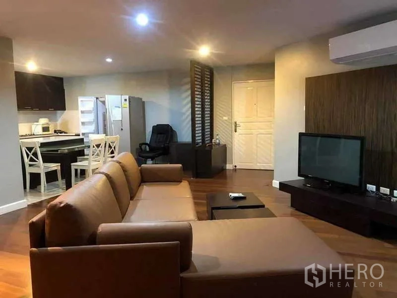 Condominium for sale in Yan Nawa, Bangkok - Open-plan lounge flowing to the kitchen with slatted partition and entry door.