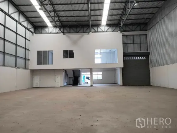 Factory for rent in Phra Nakhon Si Ayutthaya - Wide production space facing the mezzanine office block and motorized shutter entrance.