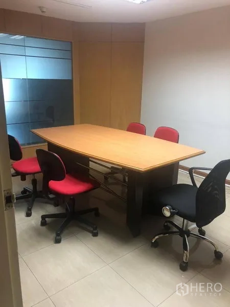 Office Space for rent in Sathon, Bangkok - Small meeting room with an oval table and wheeled chairs beside a glass partition.