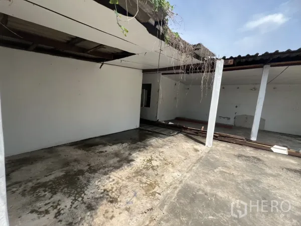 Detached House for rent in Phra Khanong, Bangkok - Partially covered outdoor area with columns, exposed roof beams and concrete surface.