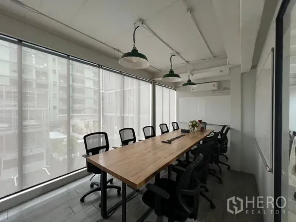Office Space for rent in Pathum Wan, Bangkok - Glass-enclosed meeting room with a 10-seat wooden table, mesh chairs and roller blinds along the windows.