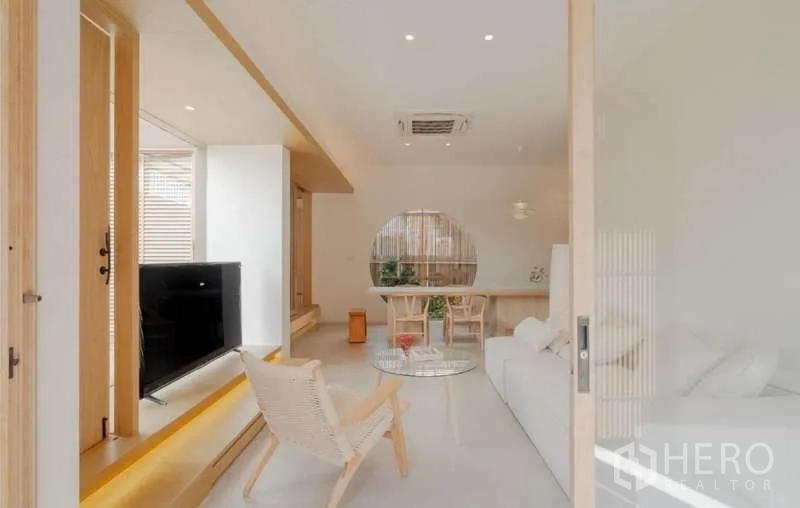 Detached House for sale in Bang Phli, Samut Prakan - Bright open-plan living room with white sofa, TV console, and dining area in minimalist wood tones.