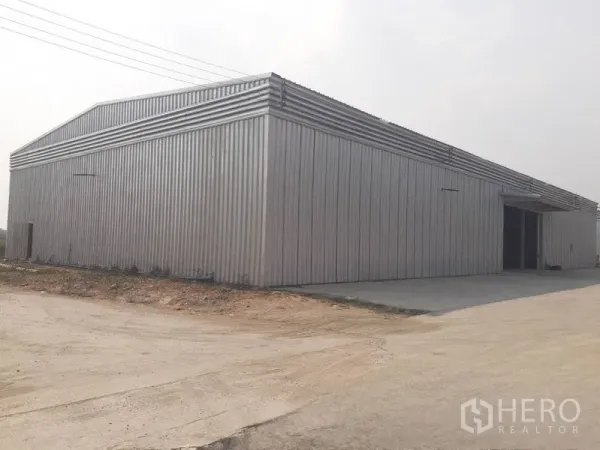 Warehouse for rent in Nong Chok, Bangkok - Open warehouse floor with ventilated wall panels and office/restroom area.