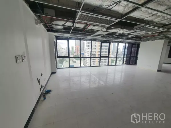 Office Space for rent in Bang Rak, Bangkok - Window‑lined area with natural light and smooth vinyl floors in a Bang Rak office.