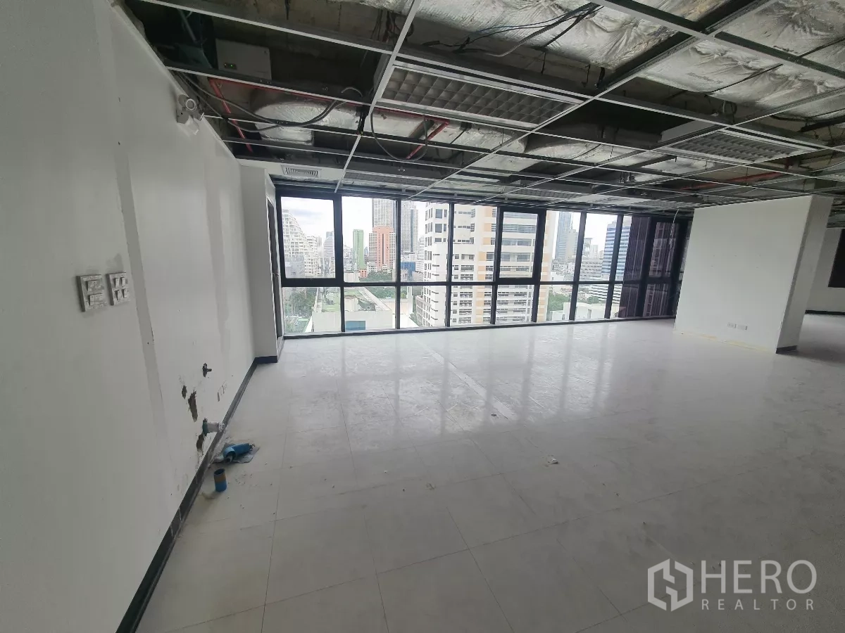 Office Space for rent in Bang Rak, Bangkok - Window‑lined area with natural light and smooth vinyl floors in a Bang Rak office.