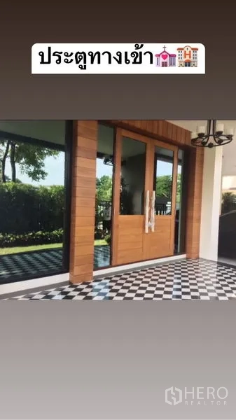 Detached House for sale in Saphan Sung, Bangkok - Grand wooden entrance door opening to a checkerboard-tiled veranda with garden outlook.