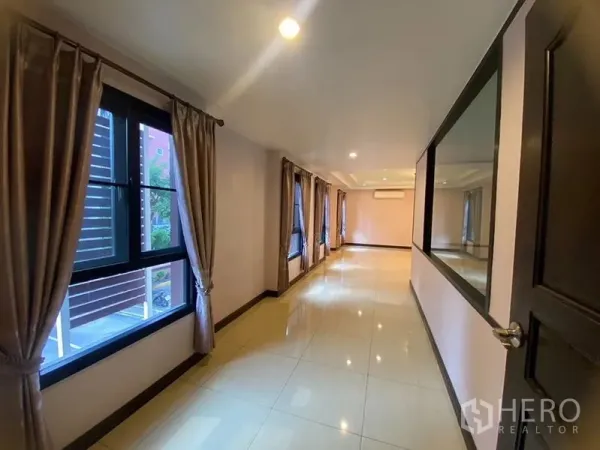 Home Office for rent in Don Mueang, Bangkok - Long corridor with tiled floor, windows and wall mirror.