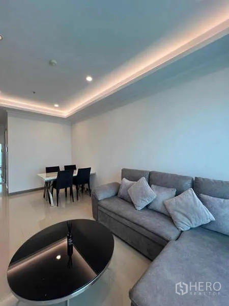 公寓 出租在Ratchathewi, Bangkok - 温馨会客区，L 型沙发与筒灯天花。
