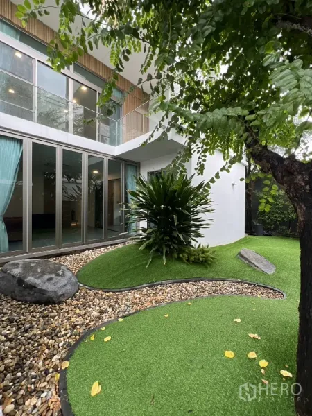 Detached House for rent in Saphan Sung, Bangkok - Landscaped garden with sliding glass doors, pebbled beds, turf mounds and lush plants.