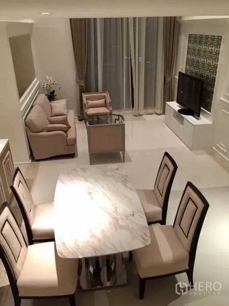Condominium for rent in Sathon, Bangkok - Bright living and dining area in a Sathon condominium with marble table, sofa set and floor‑to‑ceiling curtains.