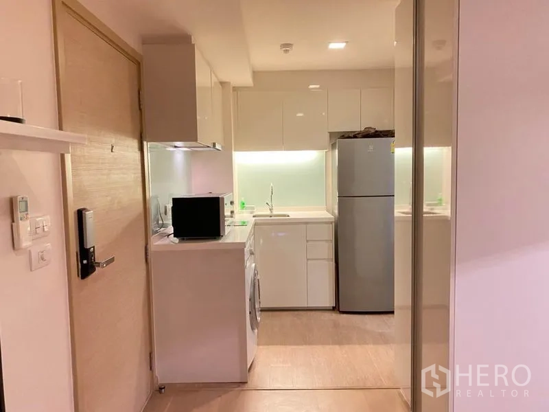 公寓 出租在Watthana, Bangkok - 纯白色小厨房，配电器、洗衣机与冰箱。