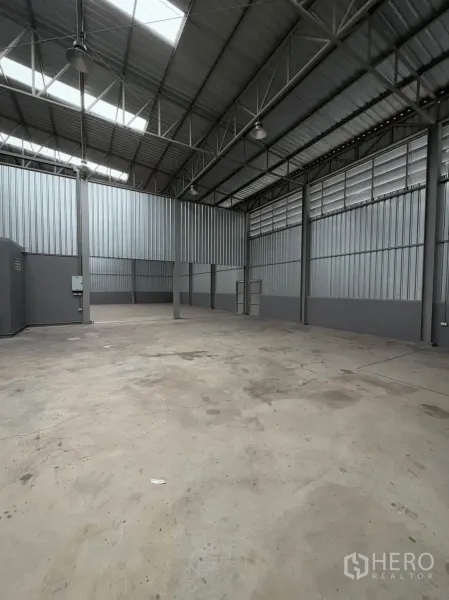 Warehouse for rent in Phra Pradaeng, Samut Prakan - Large interior space with steel columns, louvered ventilation panels, and high-bay lighting.