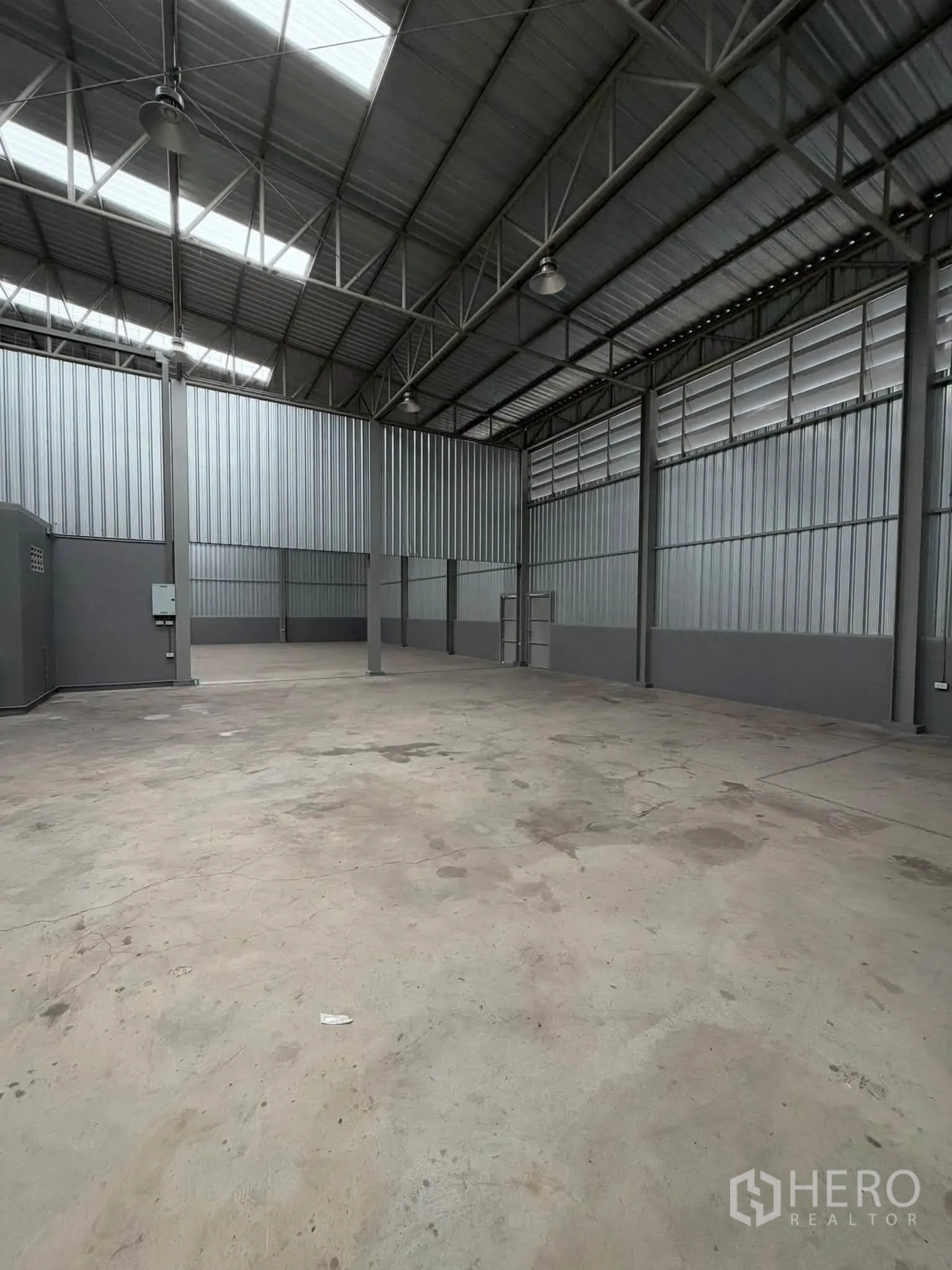 Warehouse for rent in Phra Pradaeng, Samut Prakan - Large interior space with steel columns, louvered ventilation panels, and high-bay lighting.