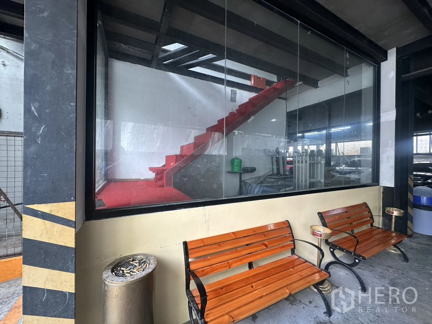 พื้นที่ขายของ for rent in Watthana, Bangkok - กระจกบานใหญ่โชว์บันไดสีแดงภายใน พร้อมม้านั่งไม้ด้านนอก.