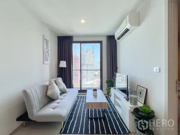 Condominium for rent or sale in Khlong Toei, Bangkok - Living area facing large window and skyline view from the sofa.