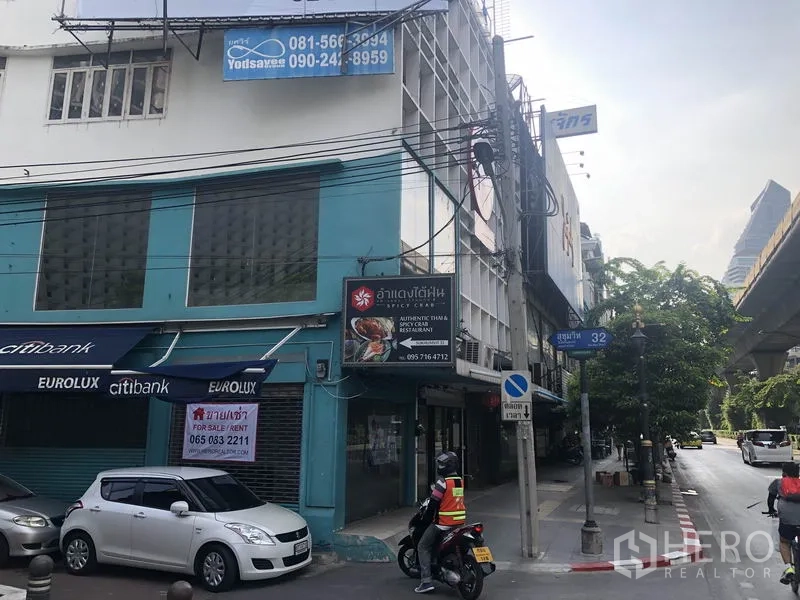 Retail Space for rent in Khlong Toei, Bangkok - Streetscape outside the property showing shophouses and the nearby BTS line along Sukhumvit.