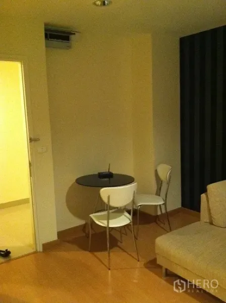 公寓 出租在Watthana, Bangkok - 紧凑用餐角，圆桌与两把椅子，靠近沙发的浅色木地板