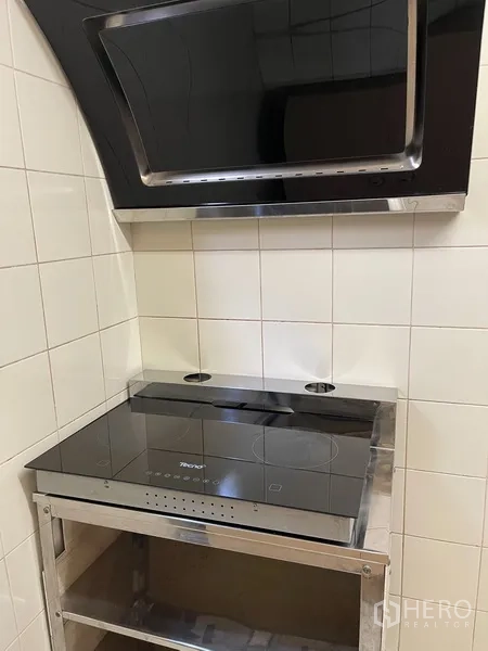 Condominium for rent or sale in Watthana, Bangkok - Close-up of electric cooktop with modern range hood and tiled backsplash.