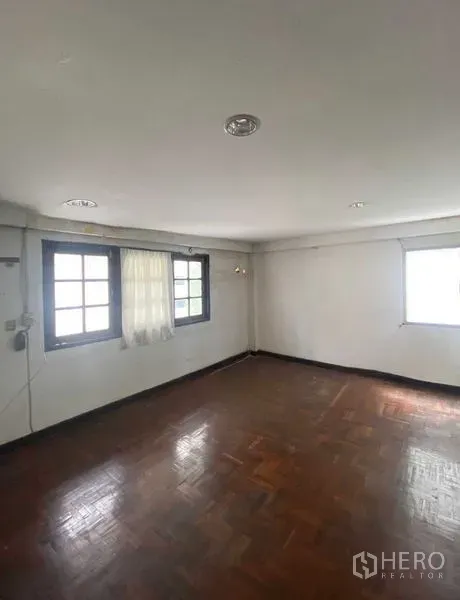 Retail Space for rent in Bang Rak, Bangkok - Bright room with parquet wood flooring, recessed ceiling lights, and two windows with sheer curtains.