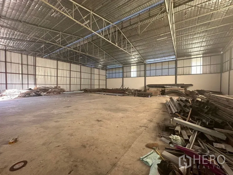 คลังสินค้า ให้เช่าในSaphan Sung, Bangkok - ฮอลล์โกดังแบบไร้เสากลาง มีช่องแสงด้านข้างและกองเหล็กวางตามแนวผนัง