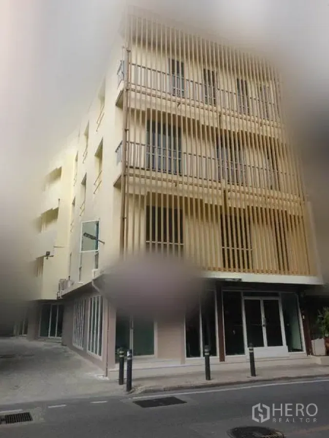 Retail Space for rent in Khlong Toei, Bangkok - Modern corner building exterior with vertical slat facade and ground-floor shopfronts.